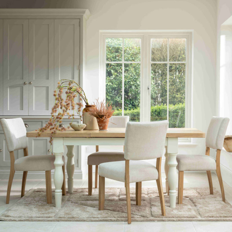 Beige upholstered chair with wooden legs on a white background