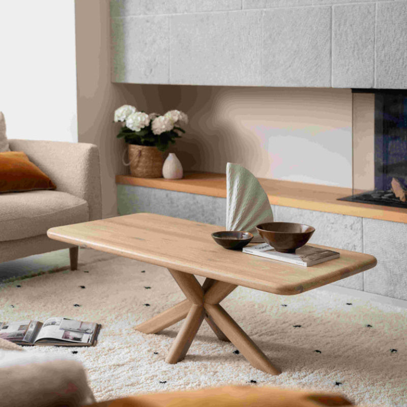 Wooden dining table with a unique base design on a white background
