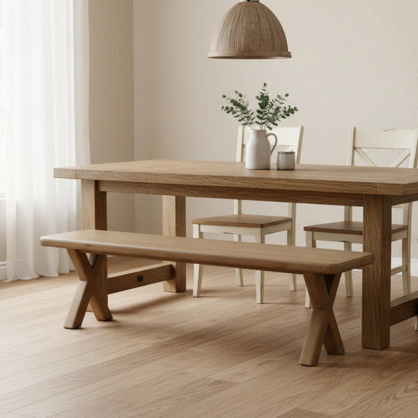 Wooden dining table with chairs and a bench in a room with light-colored walls and flooring.