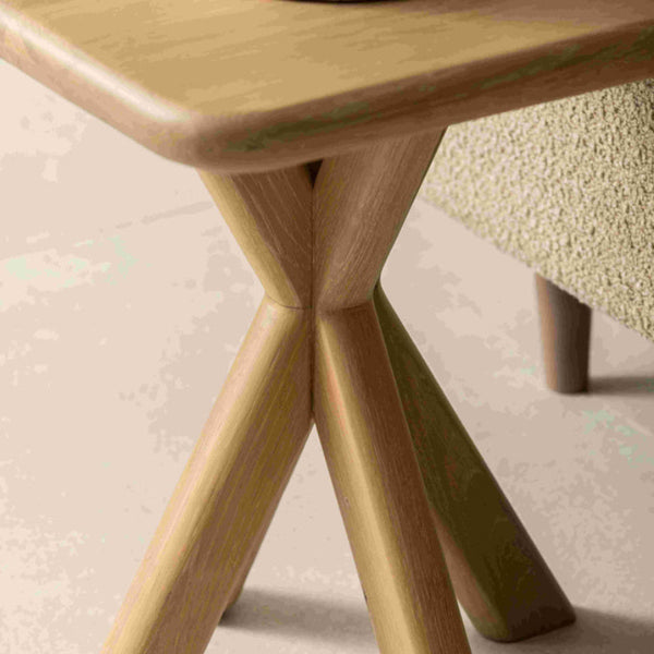 Wooden side table with a candle on a textured surface