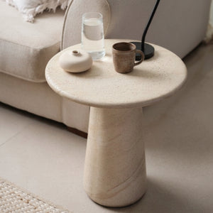 Marble side table with decorative items in a living room setting