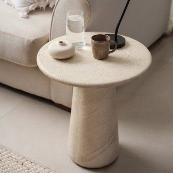 Marble side table with decorative items in a living room setting