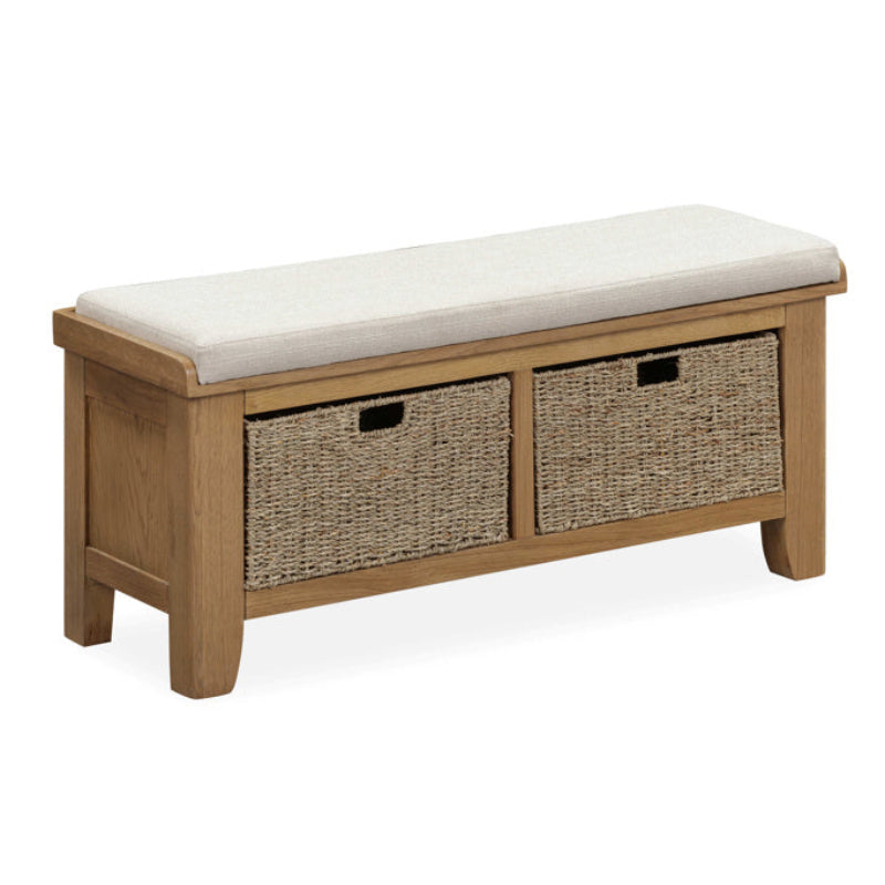 Wooden bench with white cushion and two wicker storage baskets on a white background