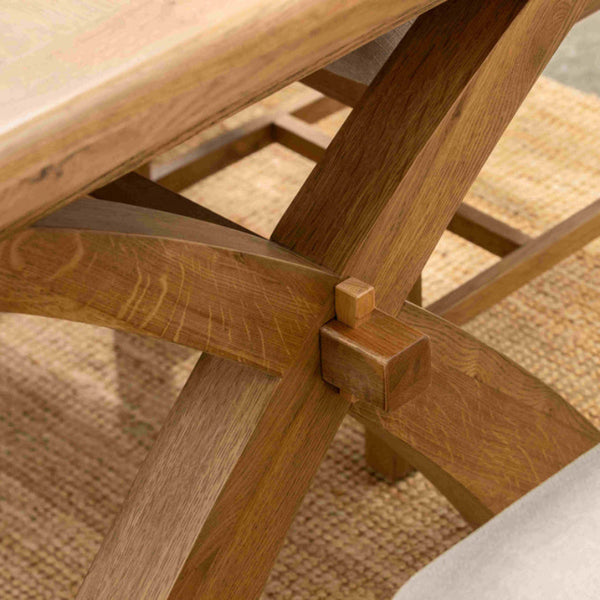 Wooden table legs with a woven mat on a wooden floor
